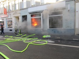 Flammen und starker Rauch strömt aus dem Schaufenster. Es brannte in einem Ladenlokal. Eine Ausbreitung auf weitere Gebäudeteile konnte verhindert werden.