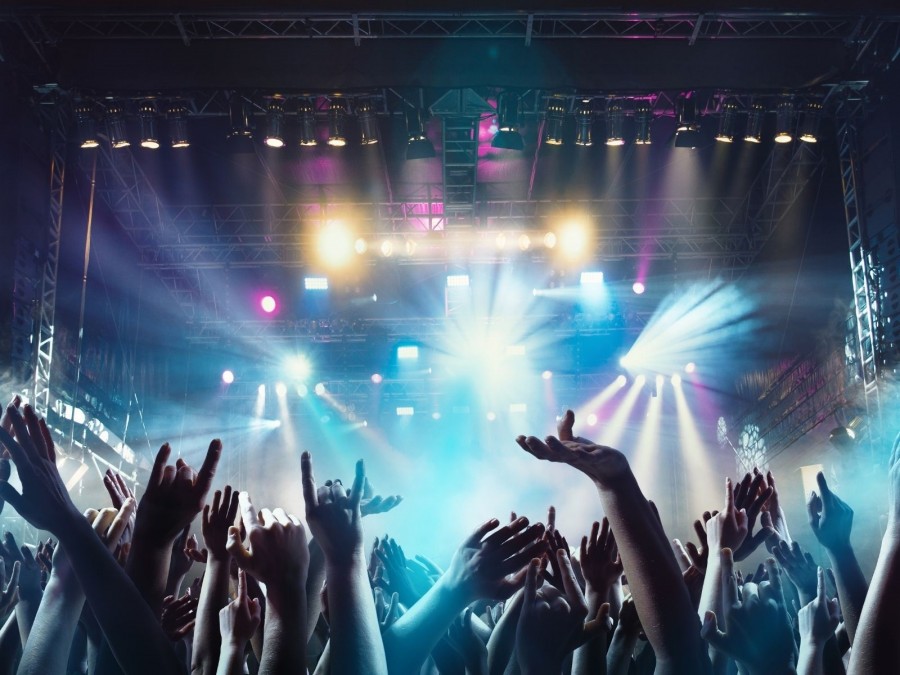 Blick in eine gefüllte Konzerthalle, Manschen halten ihre Hände und Arme hoch, Konzert, Festival, Party, Event, Veranstaltungsplanung,Publikum - Canva