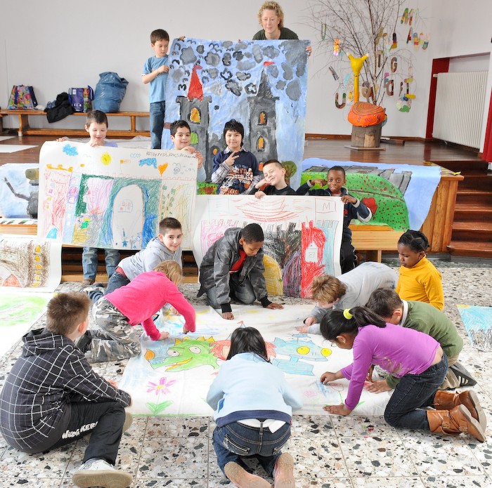 Eine Gruppe Kinder mit gemalten Bildern. Leseprojekt für Grundschulkinder. 