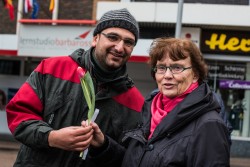 Flüchtlinge setzen Zeichen und suchen den Dialog Bewohner der Flüchtlingsunterkunft auf dem Kirmesplatz an der Mintarder Straße verteilen Blumen vor dem Mülheimer Forum
