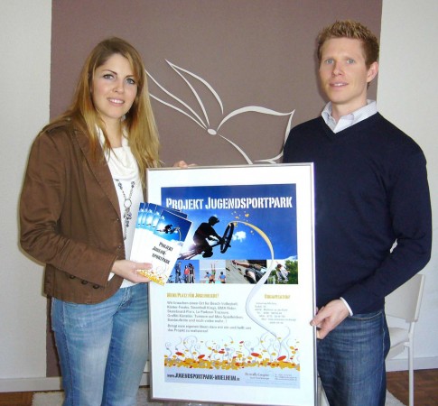 Sarah Scharfenberger, Geschäftsführerin der Werbeagentur Butterfly Graphic, übergibt dem Projektleiter Johannes Michels die neuen Flyer und Plakate 