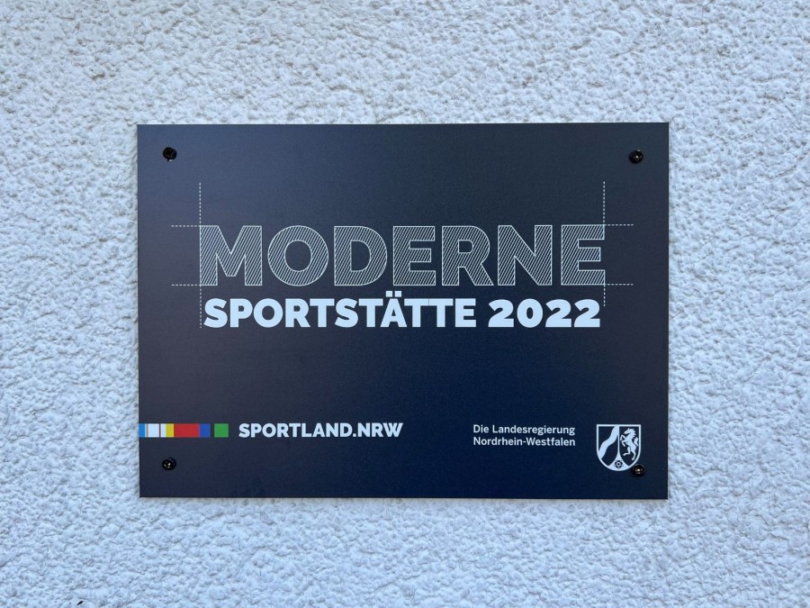 Hinweisschild Moderne Sportstätte 2022 am Vereinshaus des Dümptener Turnvereins in Mülheim an der Ruhr. - Cristina Batti