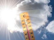 Thermometer mit hoher Temperatur vor Himmel, Sonne, Wolken. Hitzewelle, Temperaturen, Klima, 