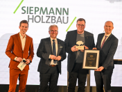 Der erste Mülheimer Wirtschaftspreis geht an die Firma Siepmann Holzbau. Moderator Aljoscha Höhn hat Oberbürgermeister Marc Buchholz auf die Bühne geholt, um Uwe Siepmann den Preis zu überreichen. Vom Beigeordneten Felix Blasch gab es außerdem eine Urkunde. (v.li.)