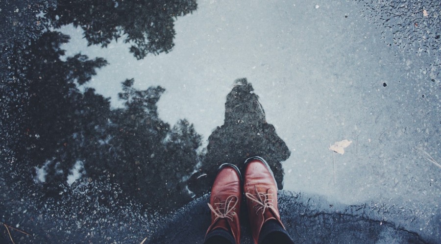 Person in braunen Schuhen steht in einer Pfütze auf betoniertem Boden. - Photo by Krissana Porto on Unsplash