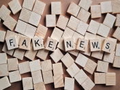 Buchstaben des Scrabble-Spieles auf Holzplättchen zusammengelegt zu Fake News.
Verschwörungsideologien, Verschwörungstheorien, Verschwörungserzählungen