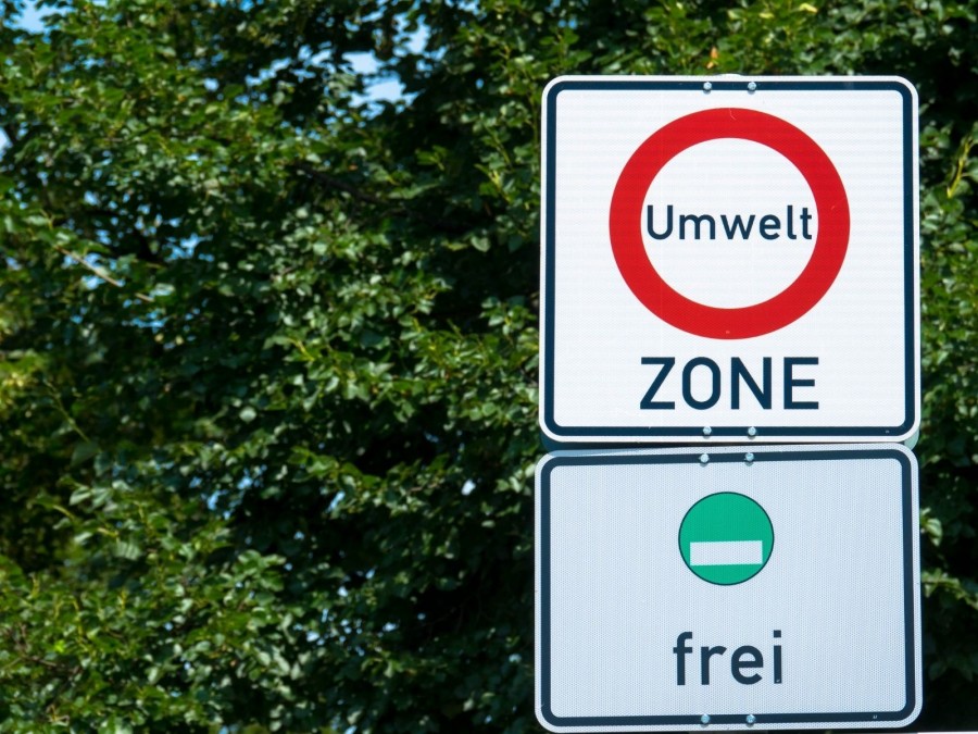 Verkehrsschild mit Umweltzone und der Angabe, dass die grüne Plakette frei ist. Feinstaubplakette für die Umweltzonen, Luftqualitätsrichtlinie - Canva