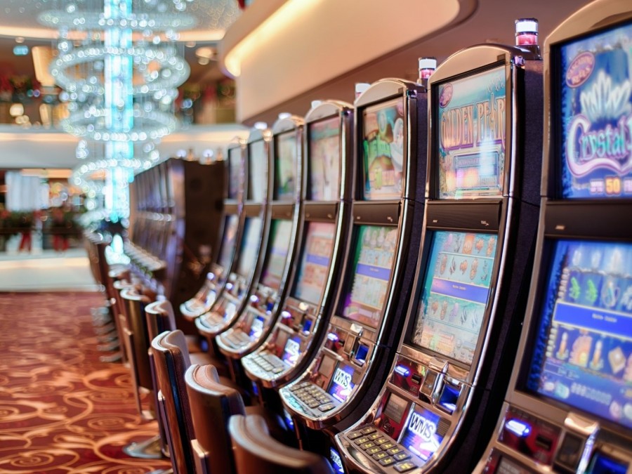 Blick in ein Casino mit Spielautomaten. Spielhallen, Glücksspiel, Vergnügungssteuer - Canva
