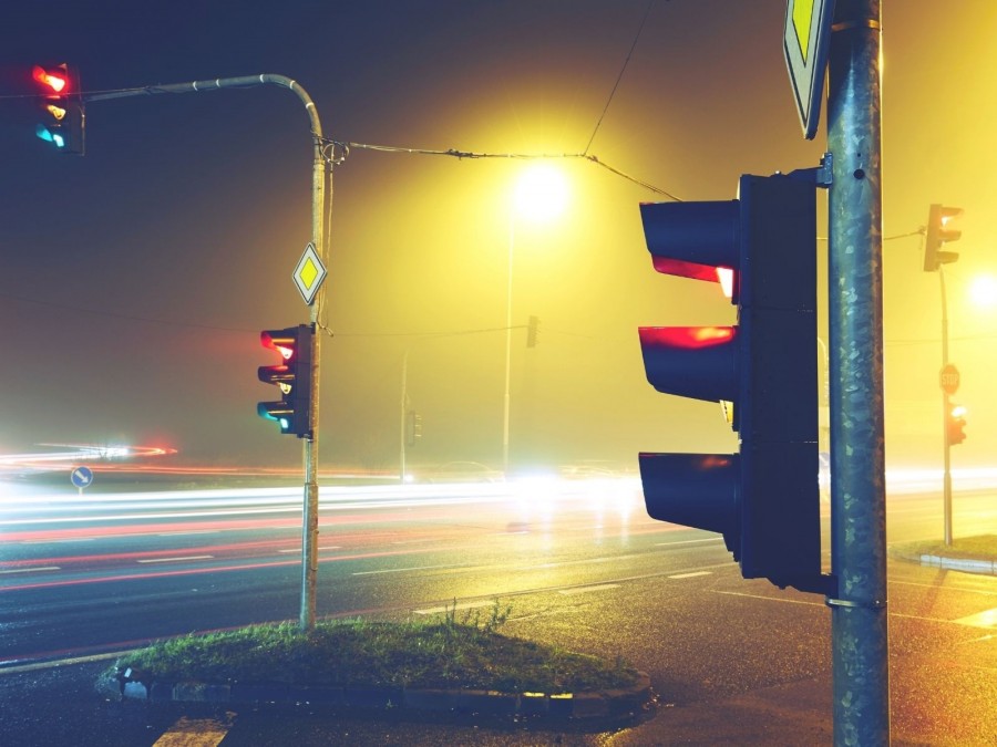 Beleuchtete Ampelkreuzung bei Nacht, die Ampeln zeigen rot. Straßeninfrastruktur, Verkehrsstruktur - Canva