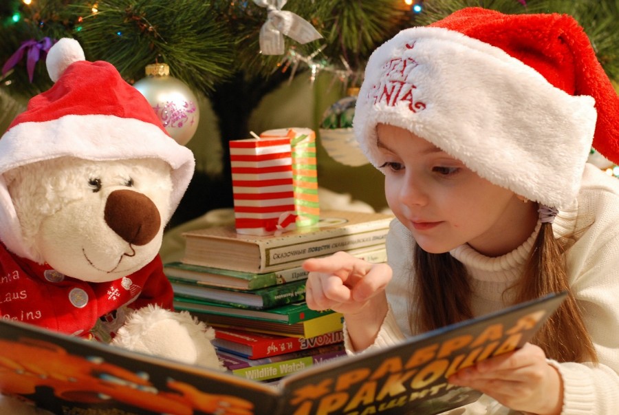 Mädchen liest ihrem Teddy aus einem Buch vor. Vorweihnachtszeit: Adventsangebot in der Stadtbibliothek im MedienHaus. - Pixabay