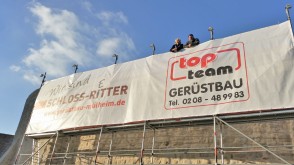 Inge Kammerichs (Geschäftsführerin der MST GmbH) und Markus Uferkamp (Geschäftsleiter top team) vor dem Schloss-Retter-Banner an der Ringmauer im November 2015.
