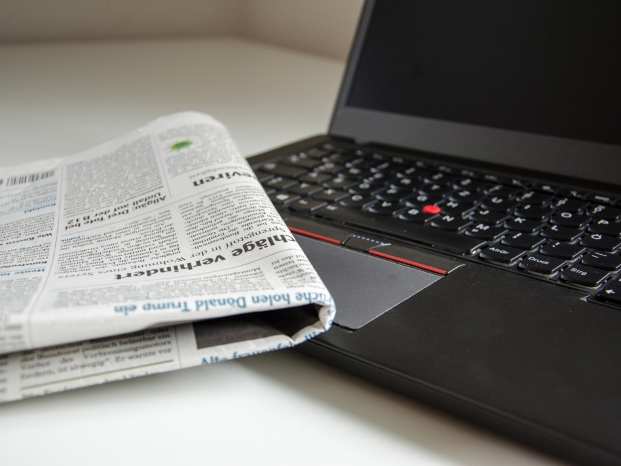 Auf dem Foto ist eine Tageszeitung, sowie ein Laptop zu sehen. Diese symbolisieren die täglichen Neuigkeiten in den verschiedenen Medien, wie Rundfunk und Zeitungen. - Online Team - Referat I - Canva - USA-Reiseblogger - Pixabay