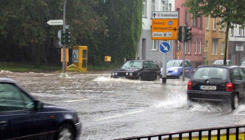 Bild der Überflutung des Dickswall nach einem Starkregenereignis, Autos stehen und fahren im hohen Regenwasser. - Amt für Umweltschutz