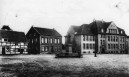 Ansicht des Klostermarkts in Saarn mit Schulgebäude und Kriegsdenkmal (1914)