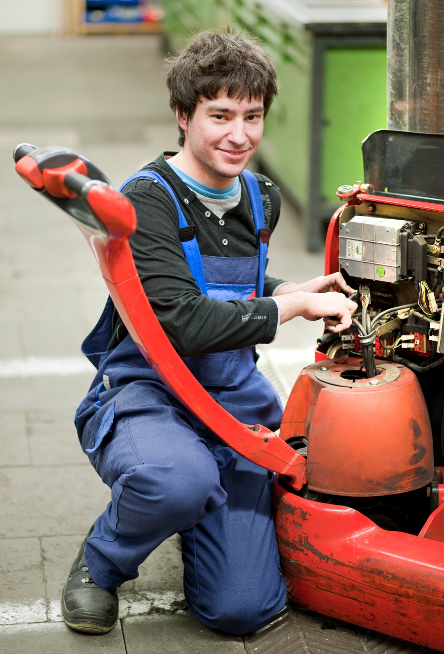 Jugendlicher, der im U25-Haus erfolgreich in Ausbildung vermittelt wurde. Er arbeitet als Industriemechaniker an einer Maschine.