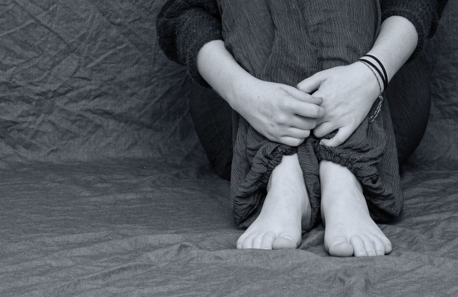 Eine Frau hat sich zurückgezogen und hat Angst. Symbol für Häusliche Gewalt gegen Frauen - Pixabay