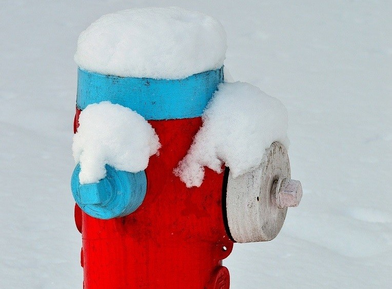 Bildzuschnitt mit einem zugeschneiten Hydranten in rot und blau, diese müssen bei Eis und Schnee freigehalten werden - Pixabay