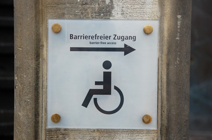 Schild Schild  mit Abbildung eines Rollstuhlfahrersymbols zum barrierefreien Zugang eines Gebäudes. Rollstuhl, Behinderungen, Versorgungsamt, Handicap, Schwerbehindertenrecht, Schwerbehindertenausweis, Barrierefreiheit - Pixabay