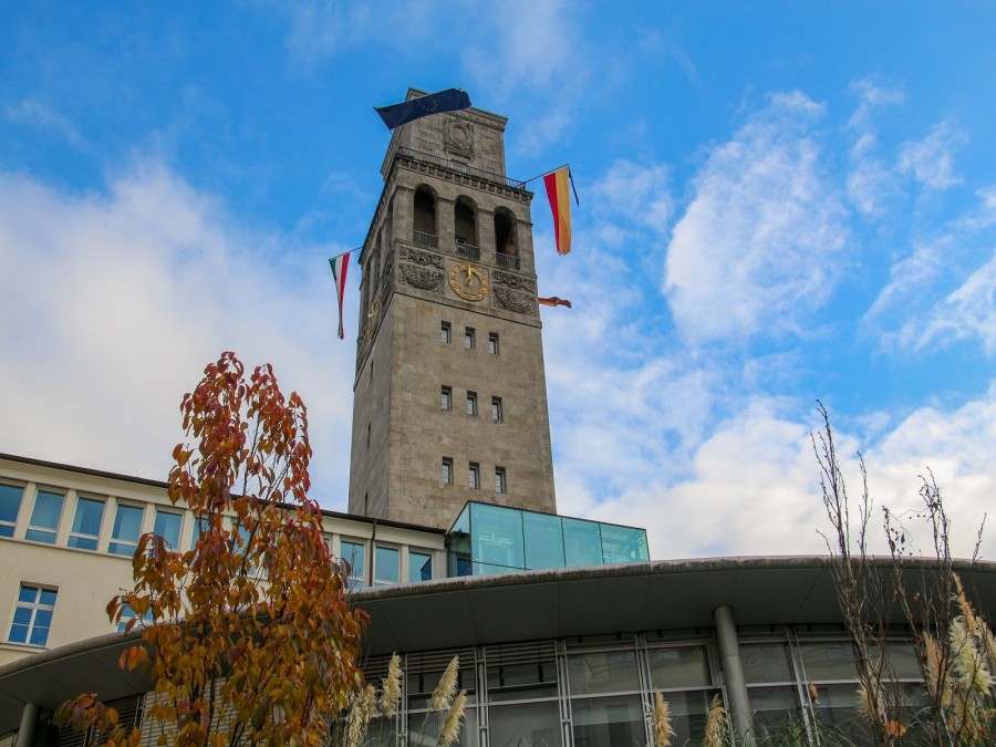Das Foto zeigt den beflaggten Rathausturm Mülheim an der Ruhr. Die Trauerbeflaggung umfasst die Flaggen von Europa, Deutschland, Land Nordrhein-Westfalen und Stadt Mülheim an der Ruhr sowie einen Trauerflor. - Sarah Sternol / Onlineteam