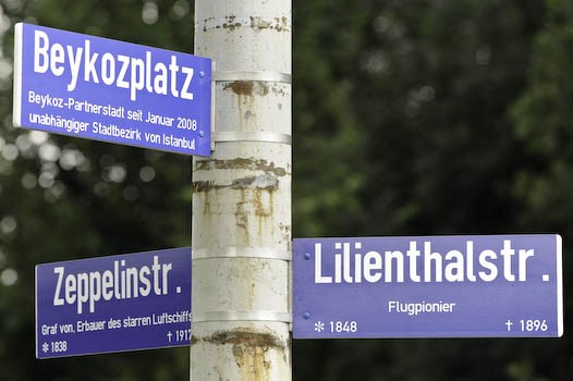 Laternenmast mit den Straßenschildern Beykozplatz, Zeppelinstr. und Lilienthalstr.. Bürger*innen können jederzeit Anregungen für mögliche künftige Straßenbennenungen geben.