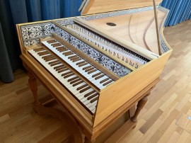 Das Bild zeigt ein Cembalo in einem Unterrichtsraum der Musikschule Mülheim. Das Cembalo zählt zu den historischen Instrumenten.