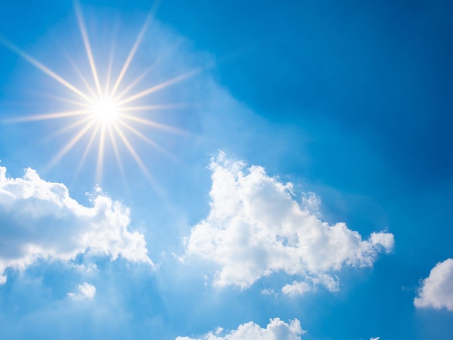 Sonne und Wolken am blauen Himmel. Die natürliche Ozonschicht schützt die Erde, Menschen und Tiere vor der schädlichen Ultraviolettstrahlung der Sonne. - Canva