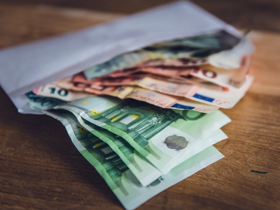 Auf dem Foto sind verschiedene Euro Geldnoten in einem Umschlag abgebildet. - Online Redaktion - Referat I - Canva