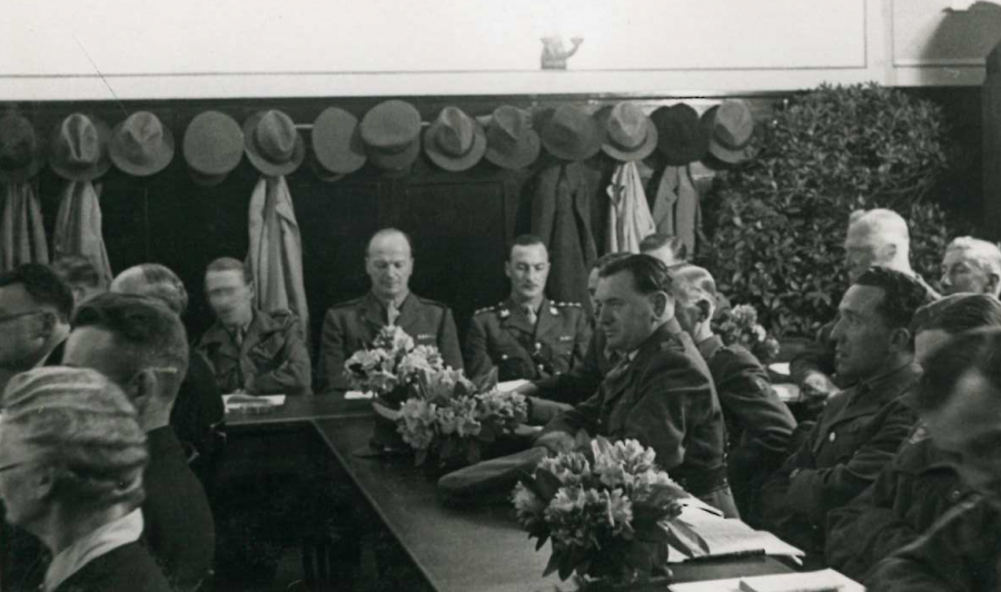 Erste Sitzung der ernannten Stadtvertretung mit zahlreichen Vertretern der Militärregierung. (Abb. Nr. 33  Ortmanns, Abb. 81) - Stadtarchiv