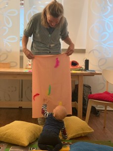 Projekt tasten trippeln tanzen- Kulturelle Bildung von Anfang an. Baby spielt mit Federn. - Jennifer Jaque-Rodney