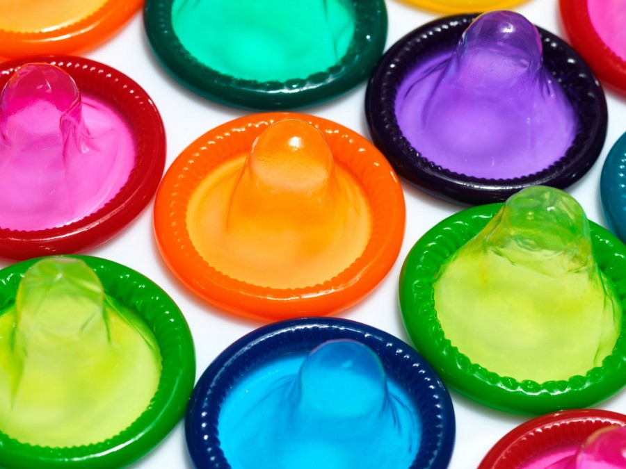 Unverpackte Kondome liegen nebeneinander auf einem weißem Untergrund in bunten Farben. - Gesundheitsamt - Canva von pederk
