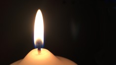 Bild einer weißen Kerze (Flamme), deren Licht hell erstrahlt.