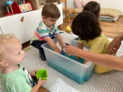 Kreative Wasserspiele, die Kinder der Tagespflege Wolke 7 mischen verschiedene Farben mit bunten Wasserkugeln