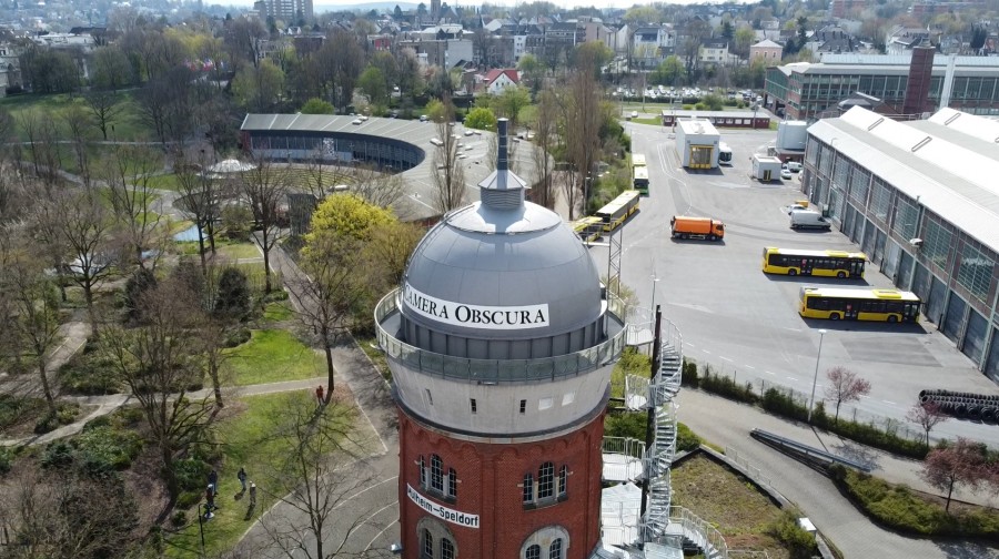 Die Luftaufnahme zeigt die Camera obscura - Museum zur Vorgeschichte des Films in der MüGa. Im Hintergrund sind der Ringlokschuppen, die Alte Dreherei und die Feuerwehr sowie das Gelände der Mülheimer Landesgartenschau zu sehen. - drohno.de