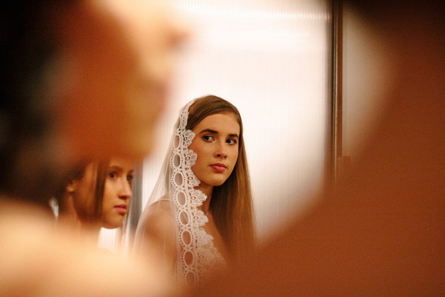 Junge Braut mit weißem Spitzenschleier, sie schaut angespannt, unglücklich zur Seite. Ein junges Mädchen steht neben ihr. Symbol für Zwangsheirat. Gleichstellungsstelle - Photo by Rachel Lees on Unsplash