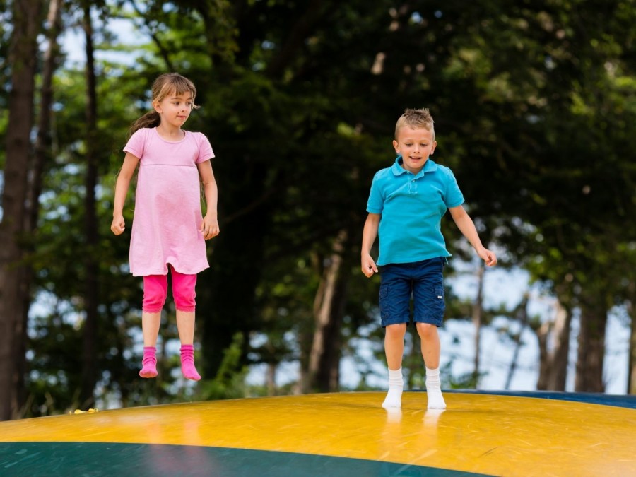 Kinder springen auf einer der Hüpfburgen, die auf dem Ferienabschlussfest im Witthausbusch am Sonntag, den 7. August 2022 von 13 bis 17 Uhr aufgebaut sind. - Online Redaktion - Referat I - Canva