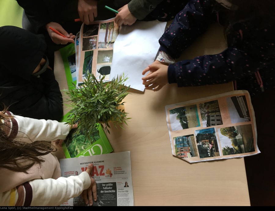 Kinder der Grundschule am Dichterviertel stehen über einen Tisch gebeugt und spielen das Eppinghofer Stadtteil:Bingo. - Lena Spörl, (c) Stadtteilmanagement Eppinghofen