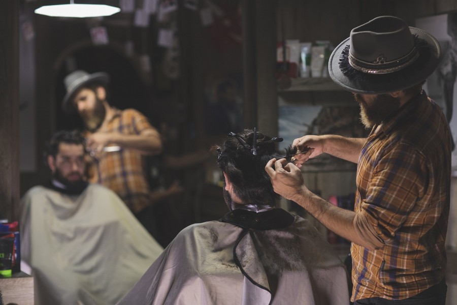 Iranischer Friseur/ Barbier schneidet einem Kunden in seinem Salon die Haare. Die Niederlassungserlaubnis ist ein unbefristeter Aufenthaltstitel und ersetzt die frühere unbefristete Aufenthaltserlaubnis und die Aufenthaltsberechtigung. Sie berechtigt zur Ausübung einer Erwerbstätigkeit, ist zeitlich und räumlich unbeschränkt. - Bild von mostafa meraji auf Pixabay