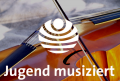 Das Logo von dem Regionalwettbewerb JUGEND MUSIZIERT auf einem Streichinstrument im Hintergrund. - Kulturbetrieb