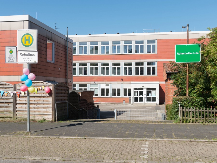 Bei der feierlichen Einweihung des neuen Namens der Ruhrstadtschule wurde auch die neue Elternhaltestelle eingeweiht. Das Schulbus-Schild und der Zaun der Schule wurden mit bunten Luftballons geschmückt. - Online Team, Referat I - Helena Grebe