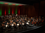 Das Sinfonieorchester der Musikschule unter der Leitung von Hyun-Su Kwon beim Weihnachtskonzert 2022 in der Mülheimer Stadthalle. Im Vordergrund die Dirigentin, im Halbkreis die Streicher, dahinter Blasinstrumente und in den hinteren Reihen die Schlaginstrumente.