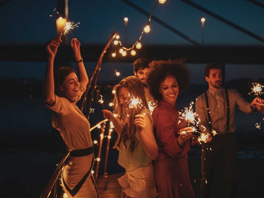 Tanzende Menschen feiern mit Wunderkerzen. Feierlichkeiten, Partys, Veranstaltungen, Volksfeste, Messen, Ausstellungen, Märkte - canva Tanzende Menschen feiern mit Wunderkerzen. Feierlichkeiten, Veranstaltungen, Veranstaltungsorte - canva