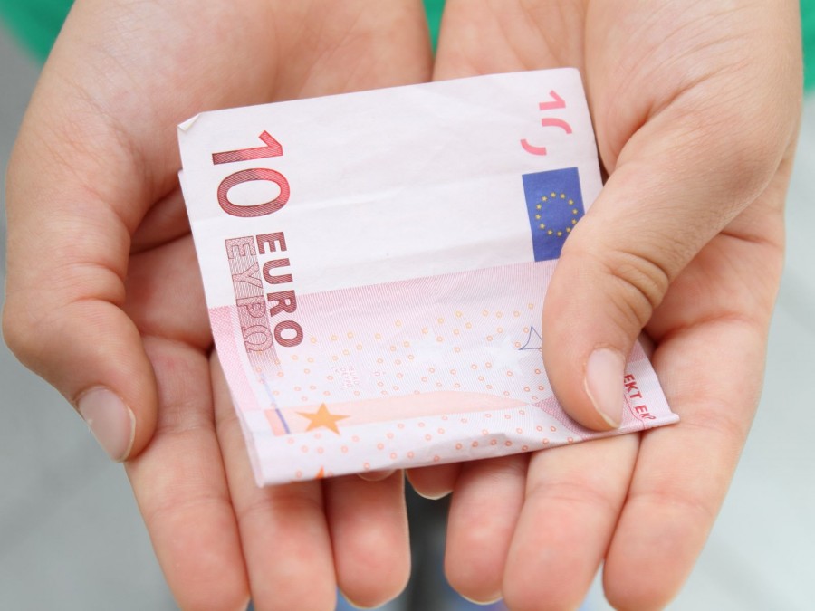 Auf dem Foto sind zwei Hände abgebildet, welche in den Handinnenflächen einen 10 Euro Schein halten. - Online Redaktion - Referat I - Canva - pheigin